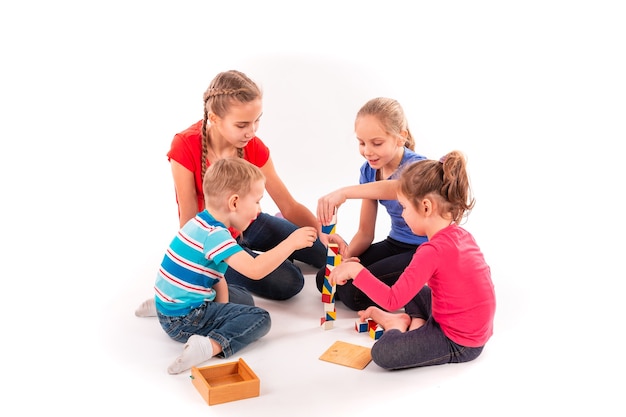 Bambini felici che giocano con le particelle elementari isolate su bianco. Lavoro di squadra, concetto di creatività.