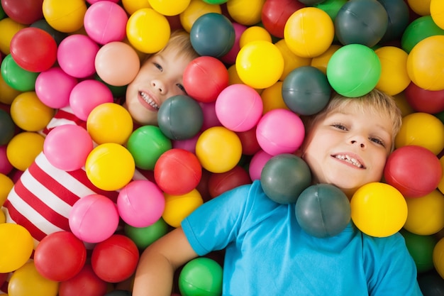 Bambini felici che giocano in piscina di palline