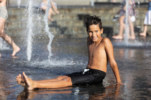 Bambini felici che giocano in una fontana