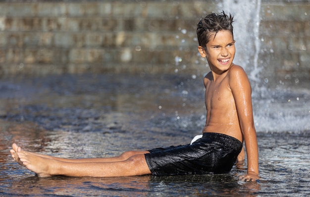 Bambini felici che giocano in una fontana