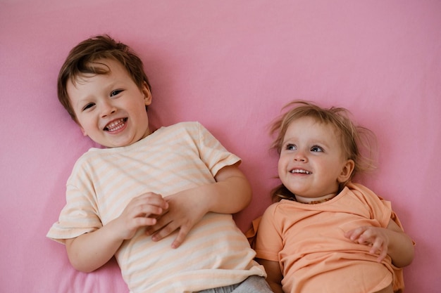 Bambini felici che giocano sul letto colorato al mattino