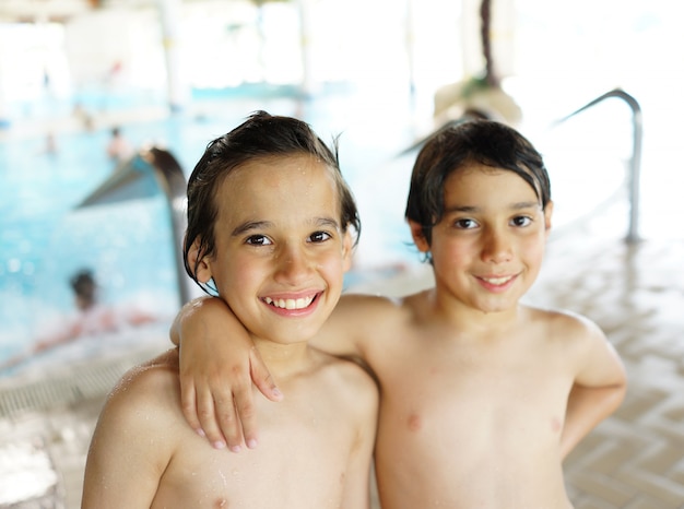 Bambini felici che godono sulla piscina estiva