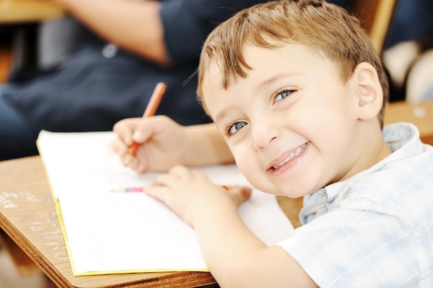 Bambini felici con il loro insegnante in classe, facendo