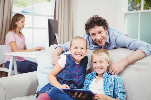 Bambini felici con il padre dal divano di casa