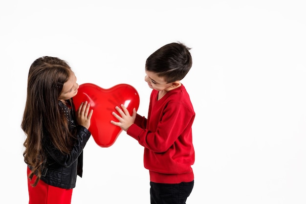 Bambini felici con palloncino cuore rosso