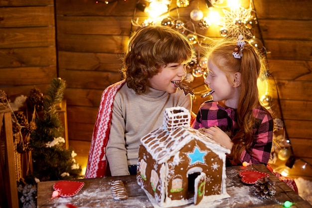 Bambini felici con pan di zenzero di Natale in una stanza decorata per le vacanze.