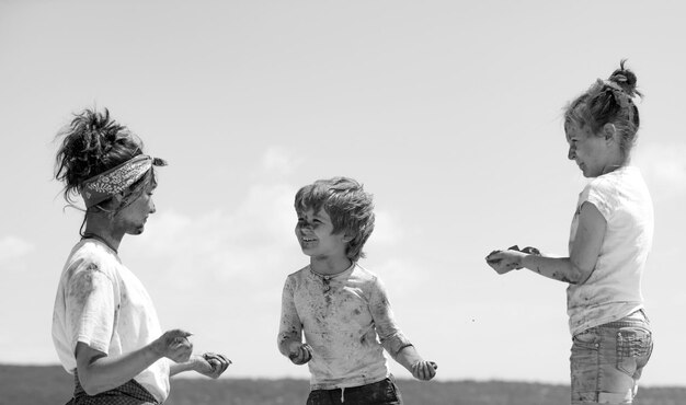 Bambini felici dell'infanzia che giocano con i colori Holi festival dei colori bambini con la faccia imbrattata di luminoso