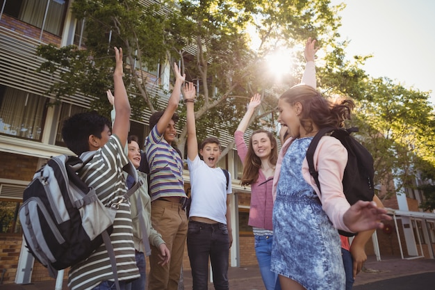 Bambini felici della scuola che si divertono nel campus