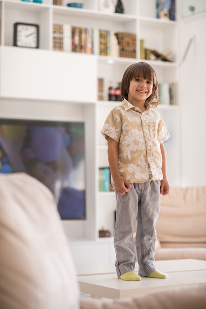 Bambini felici divertendosi e posando nella nuova casa moderna