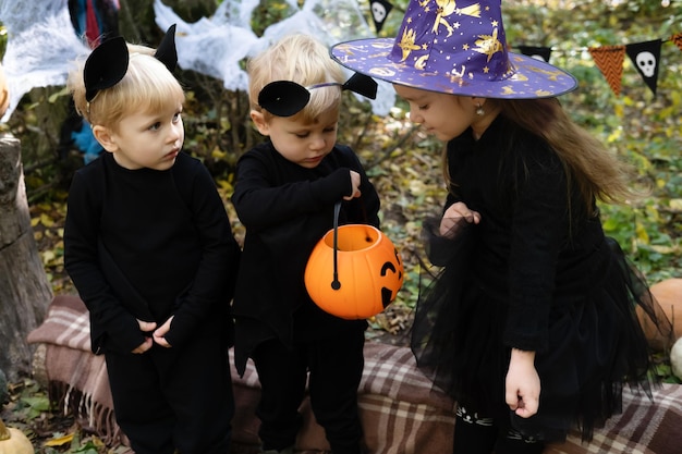 Bambini felici in costumi di Halloween che si divertono con le decorazioni di Halloween all'aperto