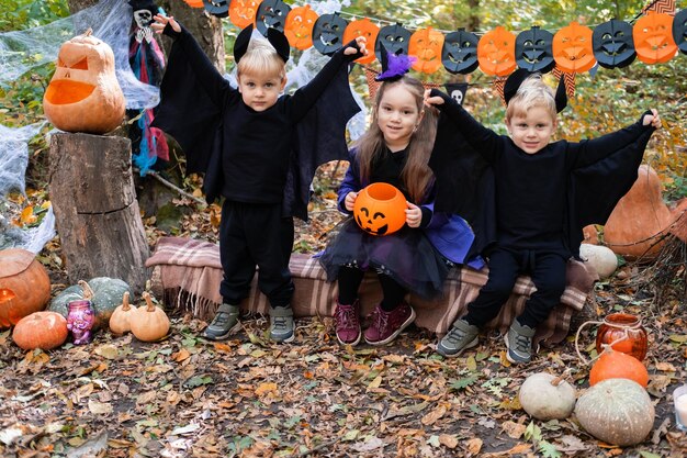 bambini felici in costumi di halloween che si divertono nelle decorazioni di halloween all'aperto