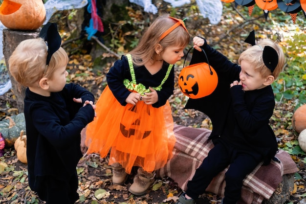 bambini felici in costumi di halloween che si divertono nelle decorazioni di halloween all'aperto