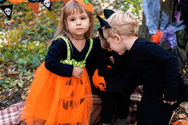 bambini felici in costumi di halloween che si divertono nelle decorazioni di halloween all'aperto