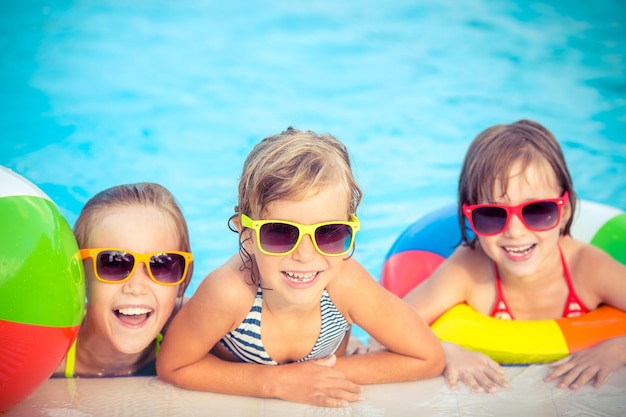 Bambini felici in piscina Bambini divertenti che giocano all'aperto Concetto di vacanza estiva