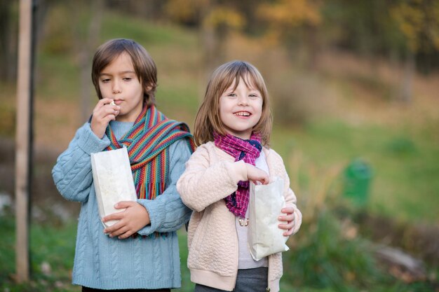 bambini felici nel parco che mangiano popcorn divertendosi in una bella giornata autunnale