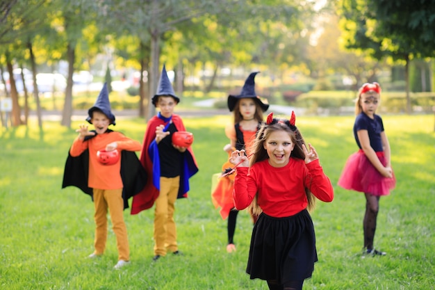 Bambini felici nel parco in costumi di Halloween celebrano la festa