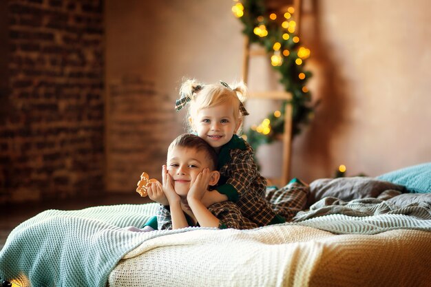 Bambini felici sul letto in attesa del nuovo anno