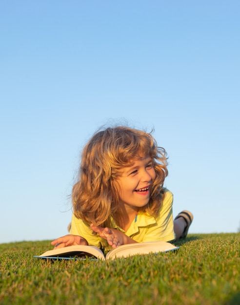 Bambini immaginazione innovazione e ispirazione bambini bambino carino che legge libro fuori sull'erba