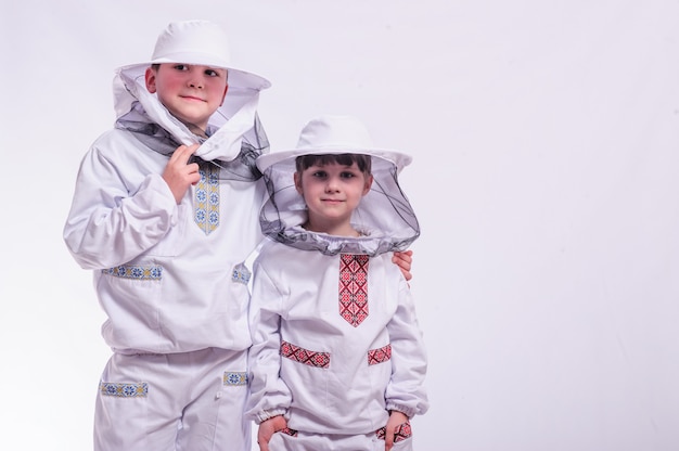 Bambini in abiti da apicoltore in posa di sfondo bianco studio.