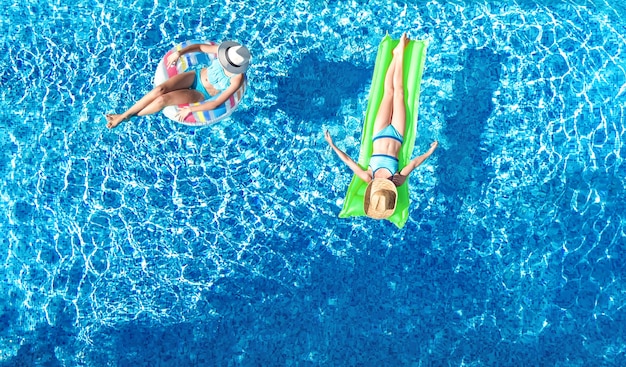 Bambini in piscina drone aerea vista dall'alto i bambini felici nuotano su una ciambella gonfiabile ad anello