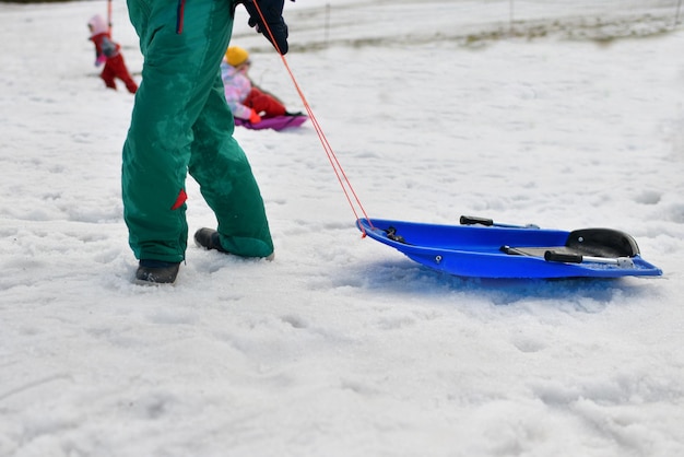 Bambini in slittino sulla neve in inverno