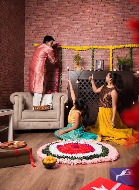 Bambini indiani che celebrano Diwali, Deepawali, Bhai Dooj o Rakhi o Raksha Bandhan con rangoli di fiori, regali, diya