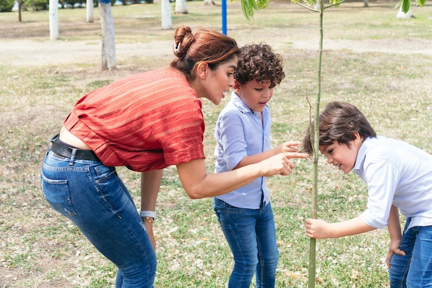 Bambini ispanici che giocano con la madre durante una passeggiata nel parco