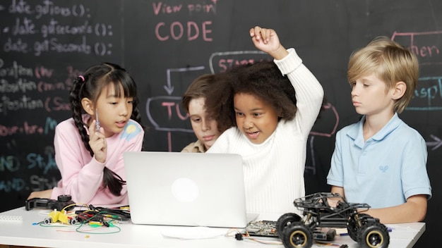 Bambini multiculturali che utilizzano il codice tecnico di programmazione del laptop Erudizione