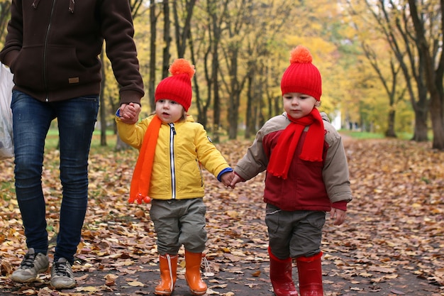 bambini nel parco autunnale con la zucca intorno alle foglie autunnali