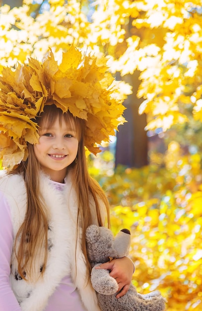 Bambini nel parco con foglie d'autunno Messa a fuoco selettiva