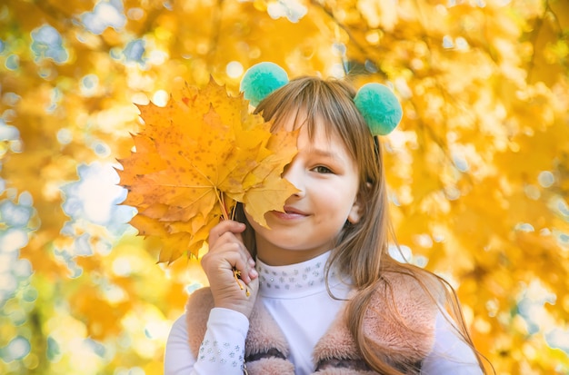 Bambini nel parco con foglie di autunno. Messa a fuoco selettiva.