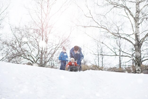 Bambini nel parco in inverno. I bambini giocano con la neve nel parco giochi. Scolpiscono pupazzi di neve e scivolano giù per le colline.