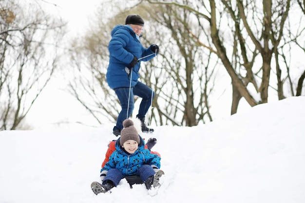 Bambini nel parco in inverno. I bambini giocano con la neve nel parco giochi. Scolpiscono pupazzi di neve e scivolano giù per le colline.