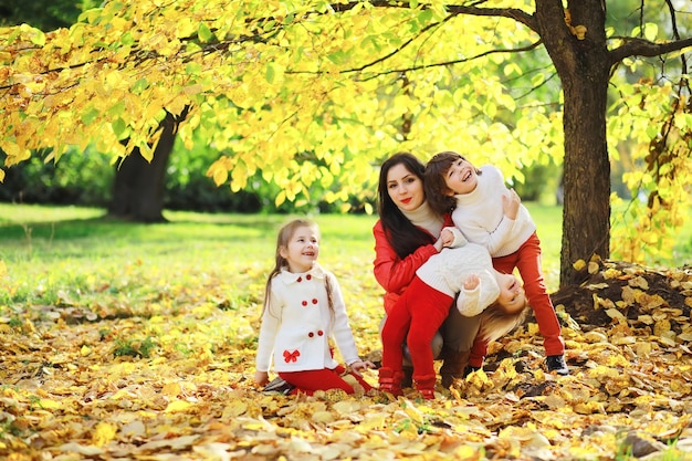 Bambini per una passeggiata nel parco autunnale. Caduta delle foglie nel parco. Famiglia. Autunno. Felicità.