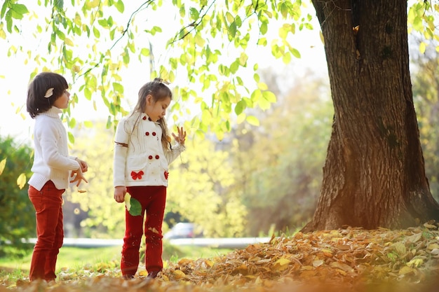 Bambini per una passeggiata nel parco autunnale Caduta di foglie nel parco Famiglia Fall Happiness