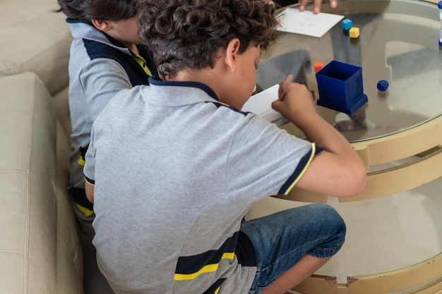 Bambini piccoli che disegnano su carta con pennarelli a casa