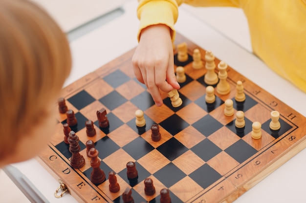 Bambini piccoli che giocano a scacchi all'asilo o alla scuola elementare