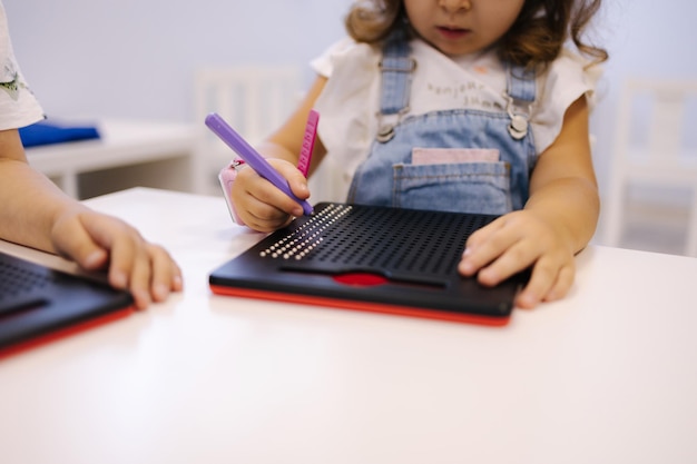 Bambini piccoli che usano la penna magnetica nei giochi educativi dell'asilo