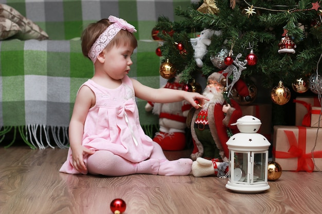 Bambini piccoli vicino a un albero di Natale prima delle vacanze