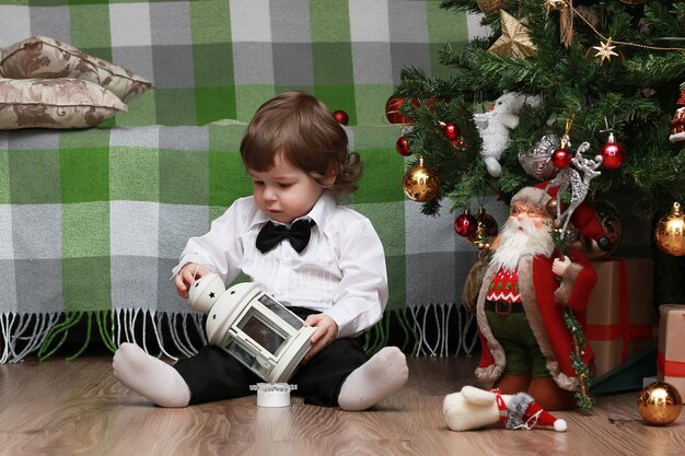 Bambini piccoli vicino a un albero di Natale prima delle vacanze