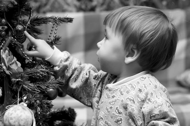 Bambini piccoli vicino a un albero di Natale prima delle vacanze