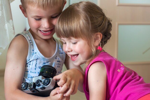 Bambini ragazzo e ragazza fratello e sorella che giocano con le macchine fotografiche.