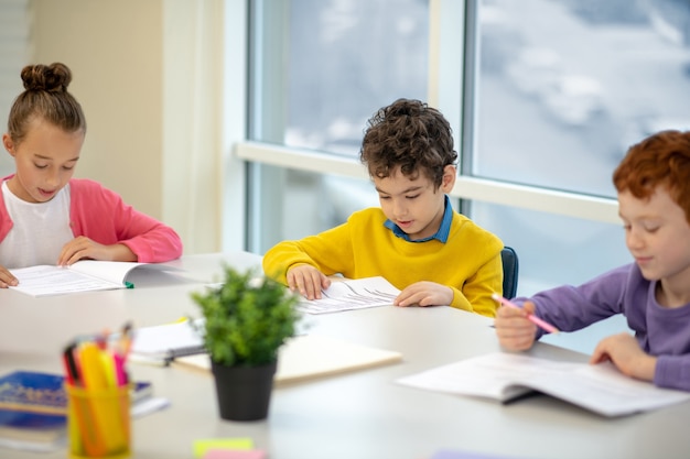 Bambini seduti al banco di scuola con un compagno di classe