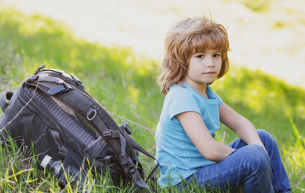 Bambini seduti nell'erba alta e ammirando le splendide viste sulle montagne e sulla natura un bambino e una bambina sulla catena montuosa del prato e sullo sfondo della foresta