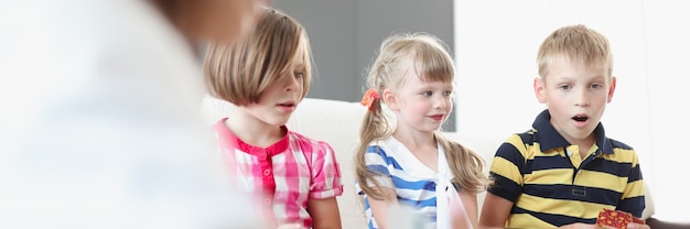 Bambini seduti sul divano che giocano a giochi da tavolo con i genitori