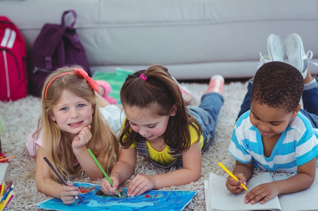 Bambini sorridenti che disegnano le immagini su carta