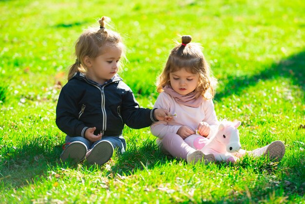 Bambini su pirnic Ragazzo carino e ragazza sedersi sull'erba sul campo estivo Bambini felici del bambino che giocano su gre