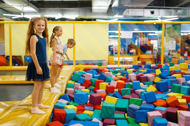 Bambini svegli che saltano sul trampolino per bambini, parco giochi nel centro di intrattenimento.