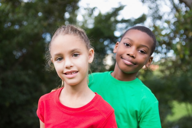 Bambini svegli che sorridono alla macchina fotografica fuori