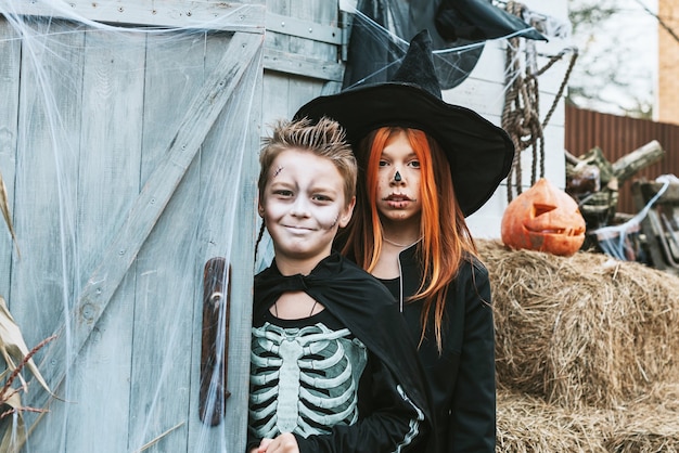 bambini un ragazzo in costume da scheletro e una ragazza in costume da strega che si divertono a una festa di halloween halloween